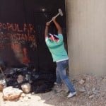 A protestor at Ni'lin symbolically smashing a part of the wall