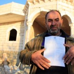 A man fro Khalit Al-Dar displays the demolition order he received.