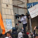 Demonstrator tries to open fence blocking access to Shuhada street