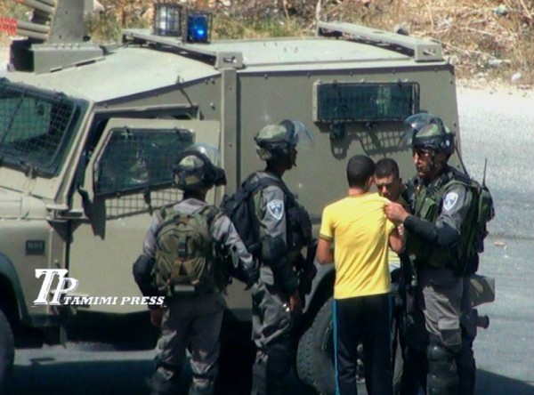 Israeli border police officer grabbing the arrested boys (Photo by TPTamimi Press)