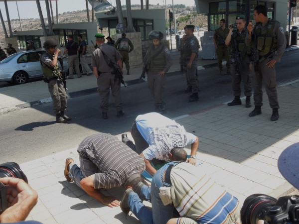 Protesters praying in front of the checkpoint to occupied Jerusalem