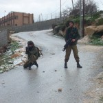 Israeli soldier pointing at residents of Urif with a M16 rifle charged with rubber coated steel bullets during a settler attack last January (Photo by ISM)