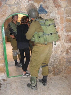 Activist blocks the door trying to prevent soldiers from entering