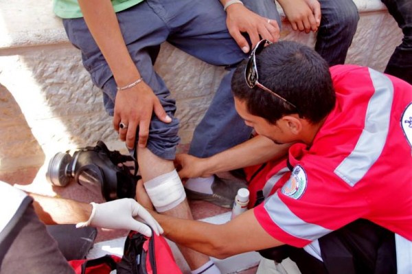 A medic treating an injured protester from rubber coated steel bullet in Nabi Saleh (Photo by Tamimi Press)