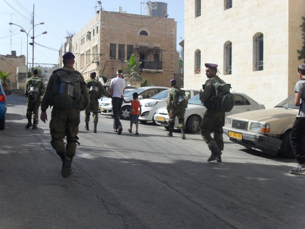 Israeli soldiers escorting Abu karem and his son to checkpoint 56 (Photo by ISM)