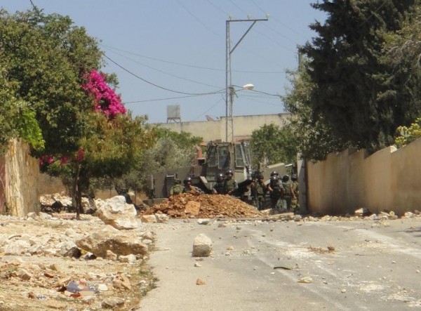 Soliders behind the new roadblock as the bulldozer retreates