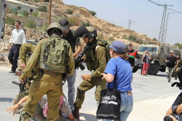 Soldiers violently pushing protester to the ground (South West Bank Popular Committee)