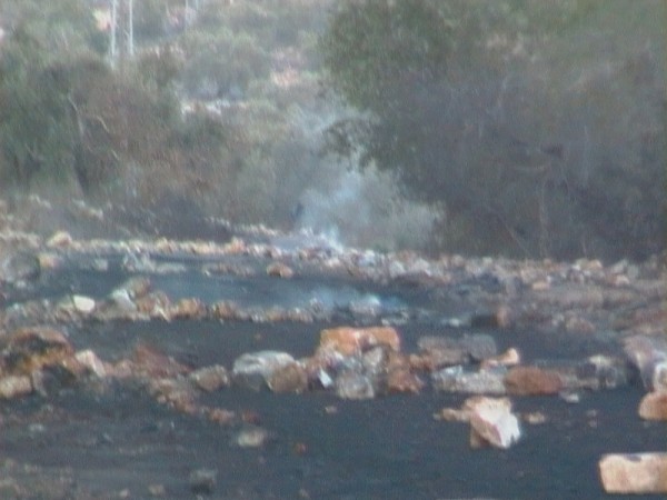 Road after Palestinian youths erected burning tires barricades (Photo by ISM)