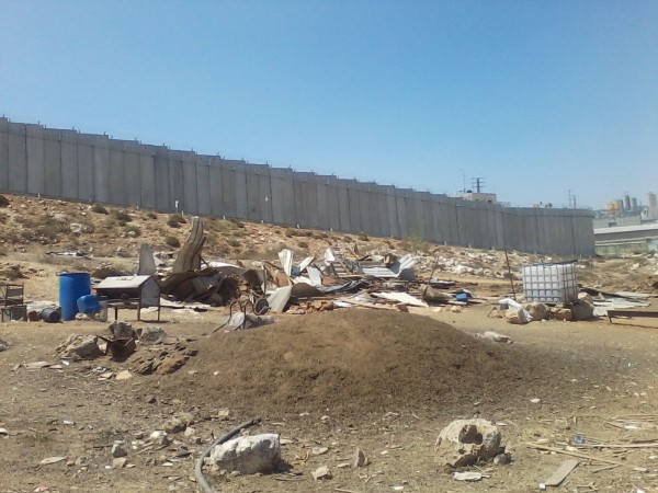 Destroyed homes and furniture in front of the Apartheid Wall (photo by ISM)