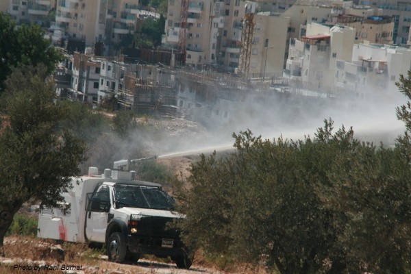 Israeli occupation forces spraying protesters with "skunk" water (Photo by Rani Bomat)