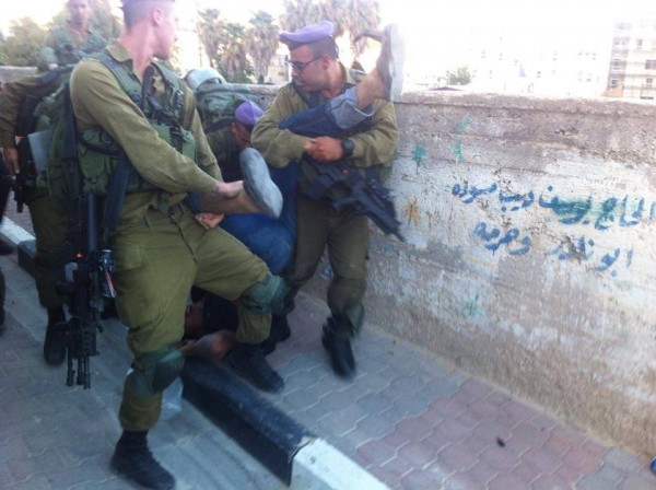 The Israeli army dropping Imad Al-Atrash on the ground (Photo by Youth Against Settlements)