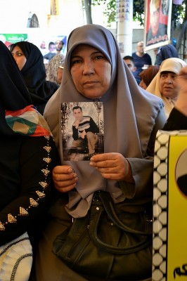 Rawda al-Najjar holds a picture of her detained son, Mohammed Ismail al-Najjar. (Photo by Rosa Schiano)