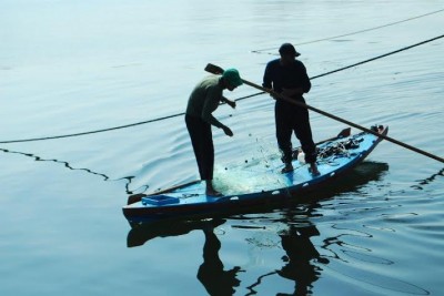 Two Palestinian fishermen paddle off the Gaza seaport. (Photo by Charlie Andreasson)