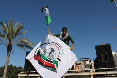 An Intifada Youth Coalition activist waves the organization's banner from a sound truck. (Photo by Joe Catron)