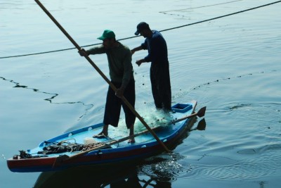 Two fishermen paddle a small boat off the Gaza coast. (Photo by Charlie Andreasson)