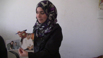 Mukarram Abu Alouf from the government Ministry of Detainees holds up two pictures of Rabee Ali, one before he was arrested and one on the day he was released. Rabee died soon after his release – photo taken by Corporate Watch, Gaza City, November 2013
