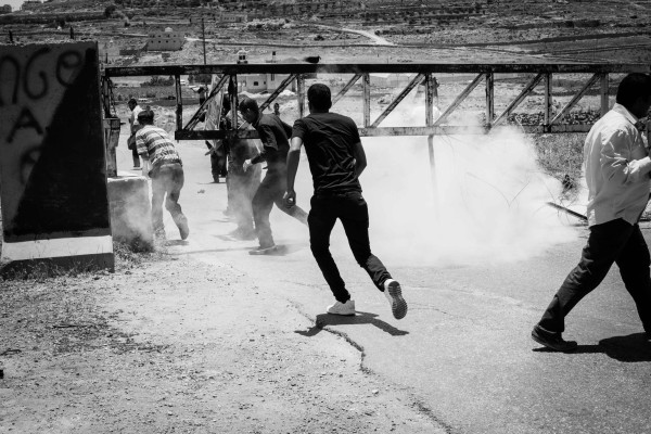 Protesters retreat after a tear gas grenade is thrown (photo by ISM).