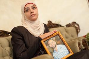 Shireen Essawi holding a photograph of her brother Samer