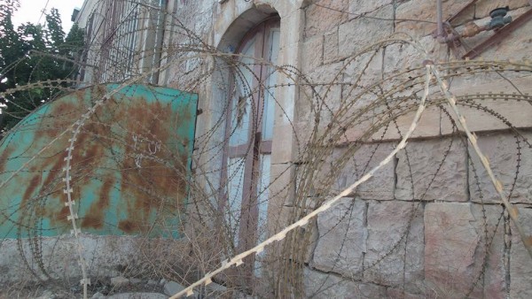 Barbed wire blocking the door to a house on Shuhada Street.