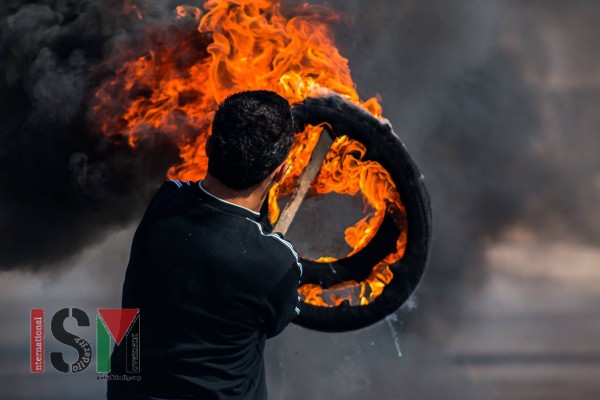 Palestinian with burning tires