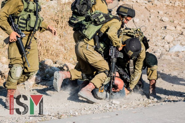 Soldiers forcing a Palestinian on the ground
