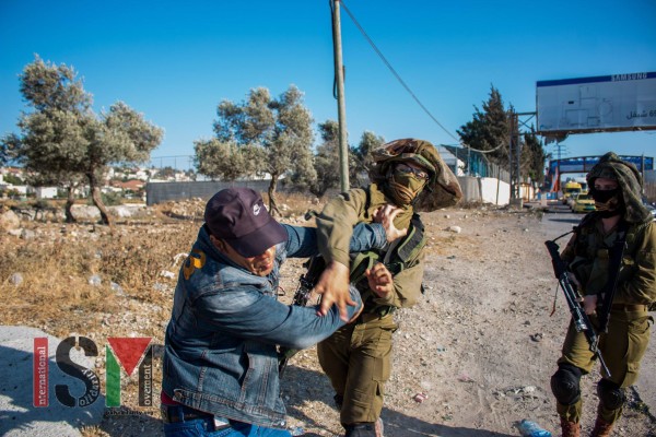 Israeli soldier hitting a Palestinian man