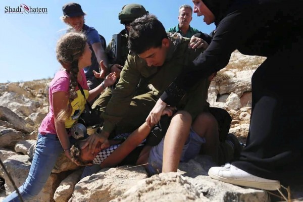 Israili soldier attacking Palestininan boy at non violent demonstration in Nabi Saleh. Photo credit: Karam 