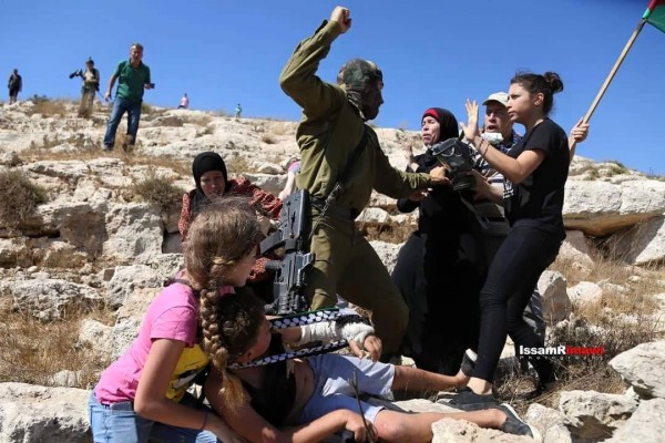 Israili soldier threatning Palestinian women and children at non violent demonstration in Nabi Saleh. Photo credit: Karam 