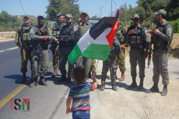 A Palestinian child protests in front of Israeli soldiers near Beit El Baraka