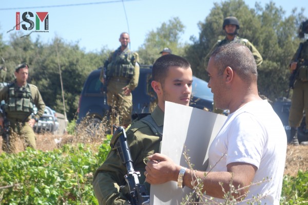 Israeli soldier confront a nonviolent Palestinian protestor near Beit El Baraka