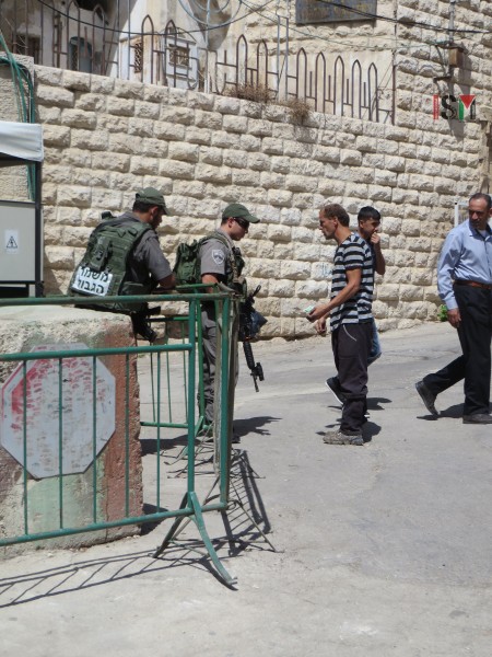 Palestinian man searched by Israeli soldiers