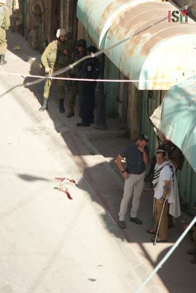 Israeli settlers standing right next to the scene of the execution