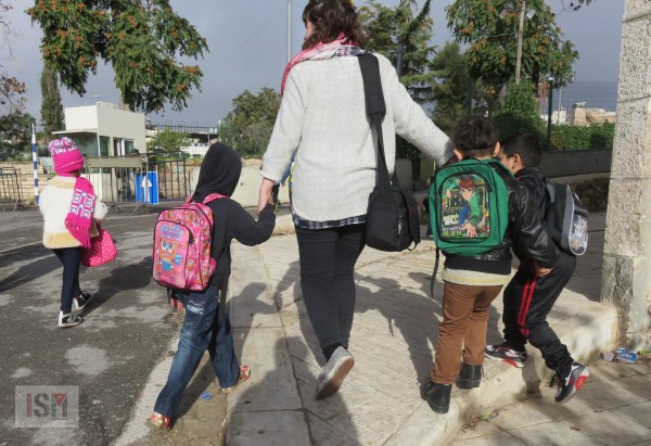 One of our volunteers walks a group of children to school in al-Khalil