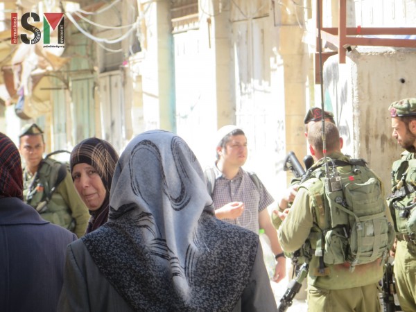 Palestinians passing by heavily-armed Israeli forces on their way home from Friday-prayer
