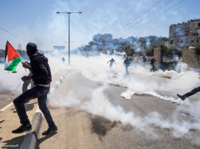 Demonstrators run from tear gas