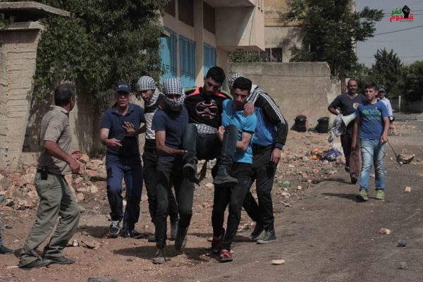 Demonstrators carrying one of the brothers to an ambulance after he was shot by Israeli forces Photo credit: Kafr Qaddum demonstration