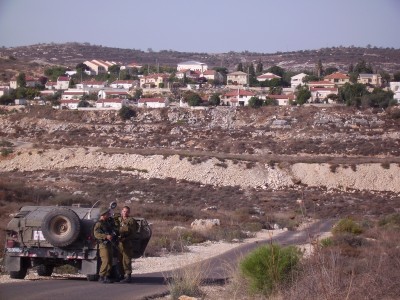 Soldiers in front of illegal settlement in Qusin