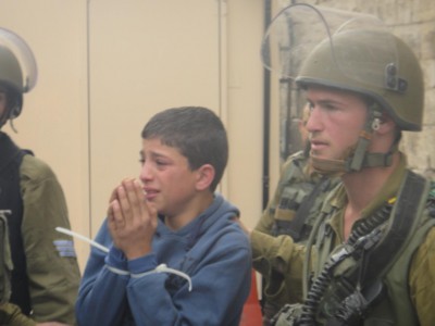 Detained child being taken to army jeep in Hebron.