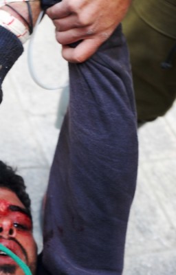 Ibrahim Saadi with wounds to head being dragged down street by soldiers 