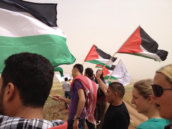 Palestinian and international activists waving Palestinian flags (Photo by ISM)