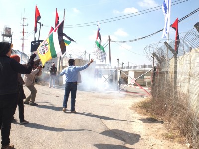 Stun grenades are thrown at demonstrators outside an Israeli military base
