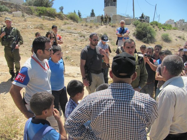 Israeli forces and Palestinian land owners arguing about the settlers tent (Photo by ISM)