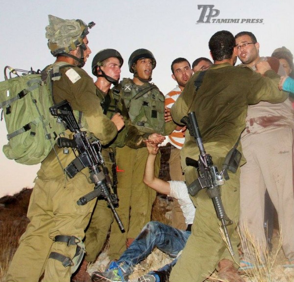 Israeli soldiers preventing people from aiding Mohammad Tamimi after he was shot (Photo by Tamimi Press)
