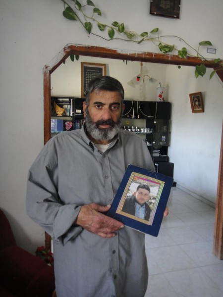 Abdallah's father with a picture of his imprisoned son (Photo by ISM)