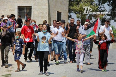 Protesters marching down the road towards the spring (Photo By Tamimi Press)