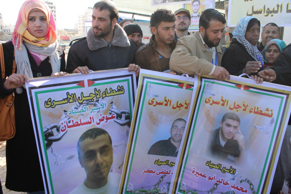 Fishermen and supporters hold posters with images of colleagues captured by Israeli forces, in Gaza City on 19 December 2013. (Photo by Joe Catron)