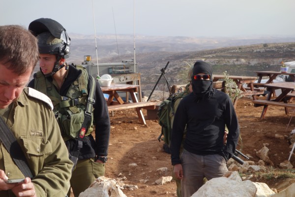 Masked settlers and soldiers on Palestinian occupied hill (Photo by ISM)
