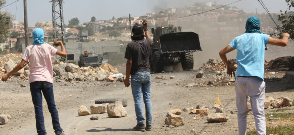 Israel army bulldozer clears the way for military jeeps to invade Kufr Qaddum (Photo by ISM)