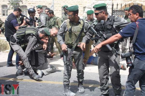 Yousef Abu Maria on his knees after occupation forces broke his arm, during the arrest