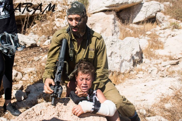 Israili soldier strangulationa Palestinian boy at non violent demonstration in Nabi Saleh. Photo credit: Karam 